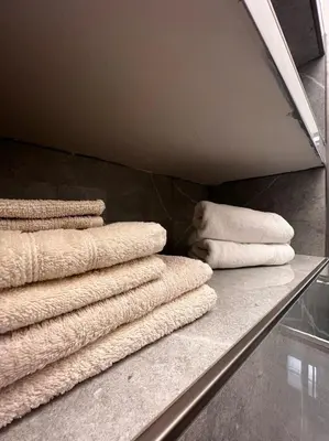 a pile of towels sitting on a shelf at Colosseum romantic home in Rome