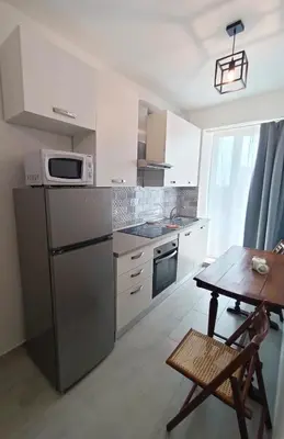 a small kitchen with a table and a microwave at La Terrazza sull'Appia by Hostand in Rome