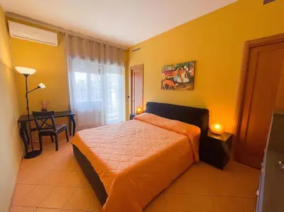 a bedroom with a bed and a table with a chair at the sun in rome in Rome
