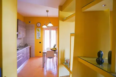 a kitchen with yellow walls and a table and chairs at the sun in rome in Rome