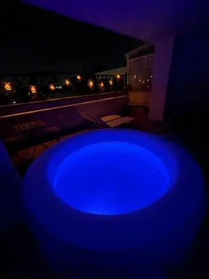 a blue hot tub on a balcony at night at Vita lenta terrazza Roma Garbatella in Rome