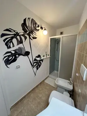 a bathroom with a white toilet and a shower at Vita lenta terrazza Roma Garbatella in Rome