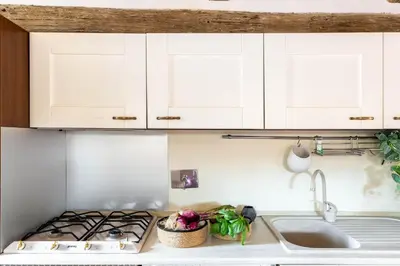 a kitchen with white cabinets and a stove top oven at iFlat Penthouse in Campo de' Fiori in Rome