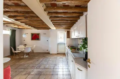 a kitchen and dining room with white cabinets and a table at iFlat Penthouse in Campo de' Fiori in Rome