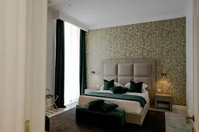 a bedroom with a large bed and a chair at Màs Boutique Hotel Rome in Rome