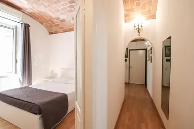 a white bedroom with a bed and a hallway at Casa Cecilia a Monti in Rome