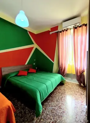a bedroom with a green bed with red and green stripes at Bed and Breakfast Mamma Giuliana in Rome