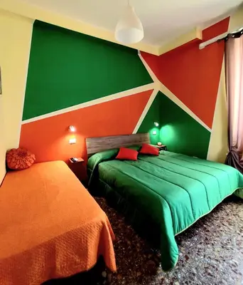 a bedroom with two beds with green and red walls at Bed and Breakfast Mamma Giuliana in Rome