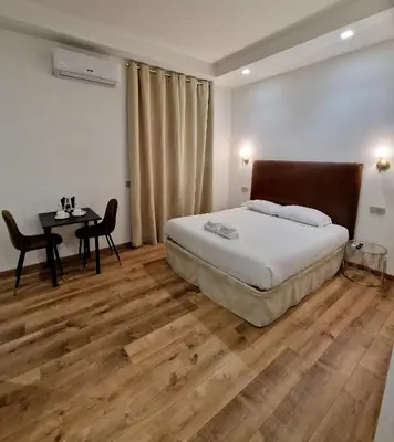 a bedroom with a bed and a desk and a table at Cuma Suites in Rome