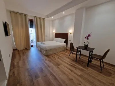 a hotel room with a bed and a table and chairs at Cuma Suites in Rome