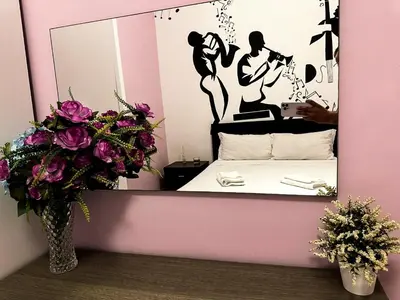 a bedroom with a mirror and a bed and flowers at Sina Rent Room in Rome