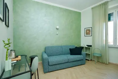 a living room with a blue couch and a table at Rohome Stay in Rome