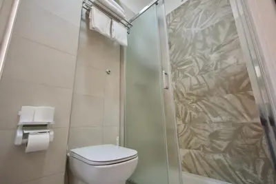 a bathroom with a toilet and a glass shower at Rohome Stay in Rome