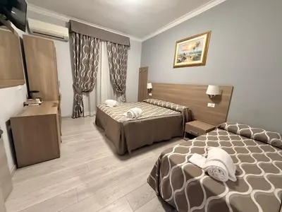 a hotel room with two beds and a window at Accommodation Corallo in Rome