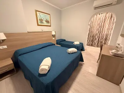 a hotel room with two beds and a table at Accommodation Corallo in Rome