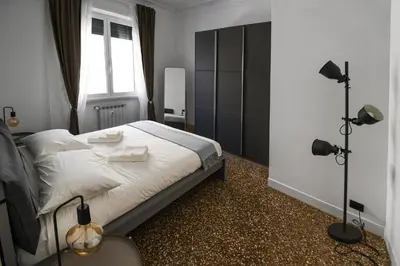 a bedroom with a bed with white sheets and a window at Aurelia's Hideaway, Near Vatican in Rome