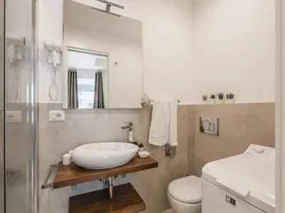 a bathroom with a sink and a toilet and a mirror at The Best Rent - Two-bedroom apartment in Colosseum area in Rome