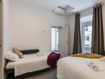 a hotel room with two beds and a window at The Best Rent - Two-bedroom apartment in Colosseum area in Rome