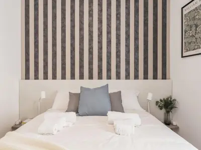 a white bed with two pillows on top of it at The Best Rent - Spacious three-bedroom apartment near the Colosseum in Rome