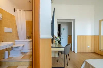 a bathroom with a toilet a sink and a table at La Maison Royale in Rome
