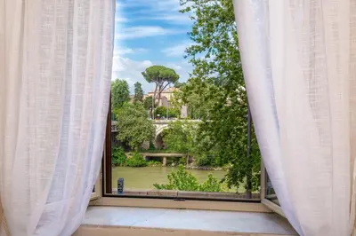 an open window with a view of a garden at Daplace - Beatrice Apartment in Rome