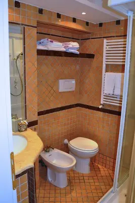 a tiled bathroom with a toilet and a sink at The Avalon in Rome