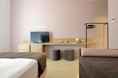 a room with a bed and a desk with a television at Youroom Quattro Fontane - Rooms in Rome