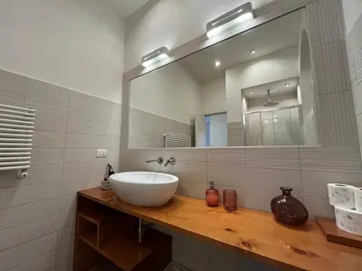 a bathroom with a sink and a large mirror at La Dolce Vita - Luxury Colosseum Boutique Apartment in Rome