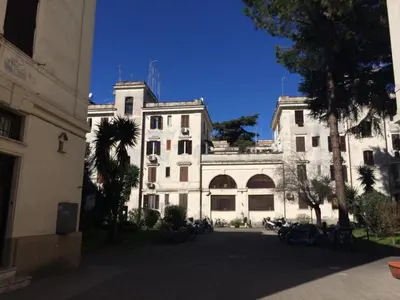 a large white building with trees in front of it at Roma Testaccio - Volta 45 apartment in Rome