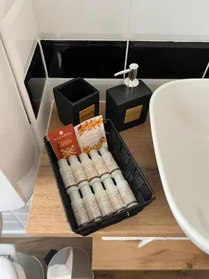 a box of toilet rolls on a table next to a sink at tibershome home la casa sul tevere in Rome