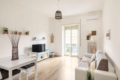 a white living room with a couch and a table at tibershome home la casa sul tevere in Rome