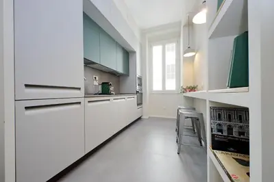 a white kitchen with white cabinets and a stool at Youcomehere - Montebello in Rome