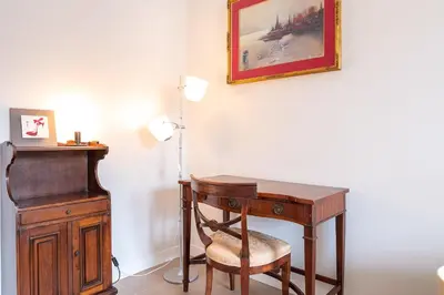 a wooden desk with a chair next to a lamp at Trastevere at heart in Rome