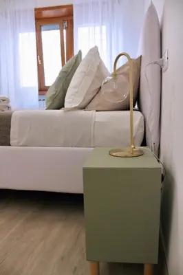 a bed with pillows and a table with a lamp at Cozy home close to the city center in Rome