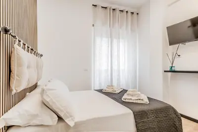 a white bedroom with a bed and a window at Casa Roma B&B in Rome