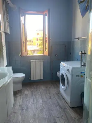 a bathroom with a washing machine and a toilet at CASA PANIERI in Rome