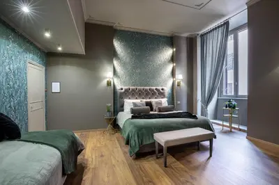 a bedroom with two beds and a bench in it at Heritage Miracle Suite in Rome