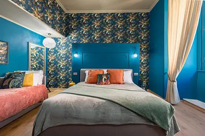 a bedroom with blue walls and a bed with orange pillows at Heritage Miracle Suite in Rome