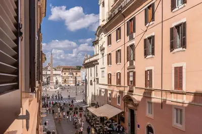 a group of people walking down a street between buildings at Heritage Miracle Suite in Rome