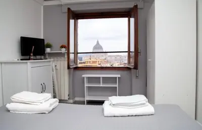 a room with two white towels on a bed with a window at Magenta Terrione 2 in Rome