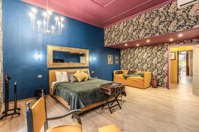 a bedroom with blue walls and a bed and a chair at Corso Miracle Suite in Rome