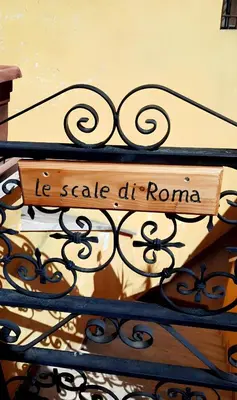 a sign that says he scale at roma on a fence at Le Scale di Roma in Rome