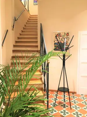 a room with a staircase with a plant and a tripod at La Torre di Castel Sant'Angelo in Rome