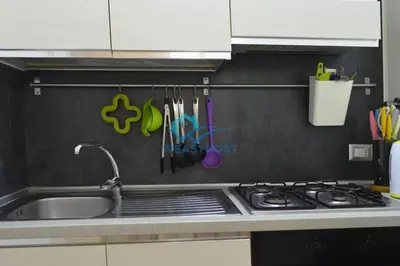a kitchen with a sink and a stove and utensils at Pigneto Modern Apartment in Rome