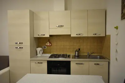 a kitchen with white cabinets and a sink at ACasaMiaSanPietro in Rome
