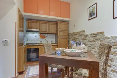 a kitchen with a wooden table and some chairs at Colosseo Residenza Sette Sale in Rome