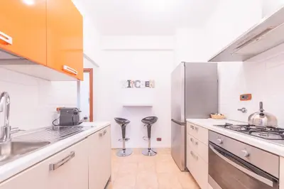 a kitchen with white cabinets and a stainless steel refrigerator at Lungotevere Apartment in Rome