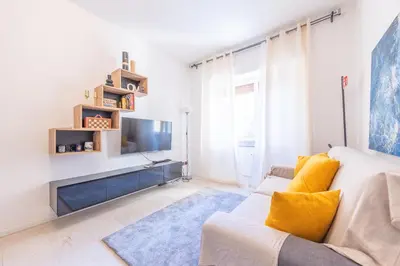 a living room with a white couch and a tv at Lungotevere Apartment in Rome