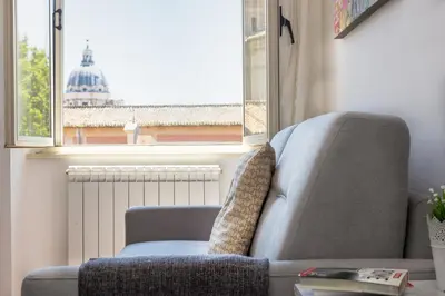 a chair in a living room with a window at Corso View by Rental in Rome in Rome