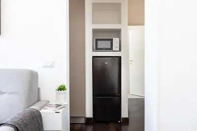 a black refrigerator in a living room with a microwave at Corso View by Rental in Rome in Rome